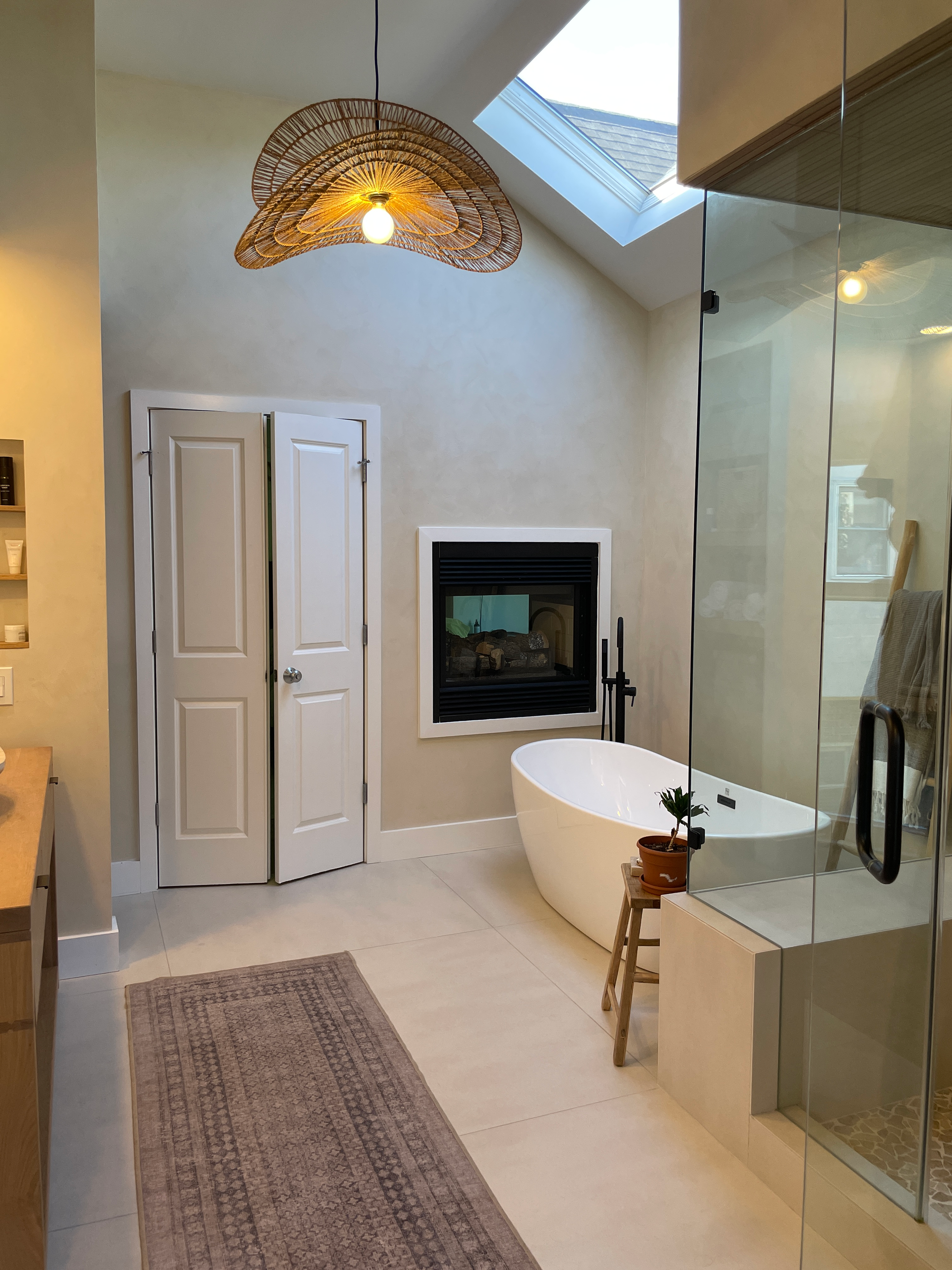 Freestanding tub beside the fireplace in the primary bath